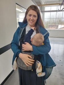 Melissa breastfeeding son in a baby carrier