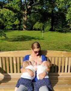 Rachel McGregor breastfeeding her infant twin sons on a park bench