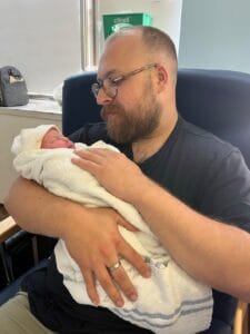 Father craddling newborn baby in hospital