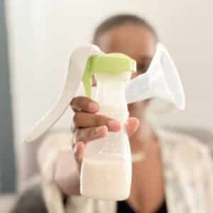 Woman holding Ardo manual breast pump